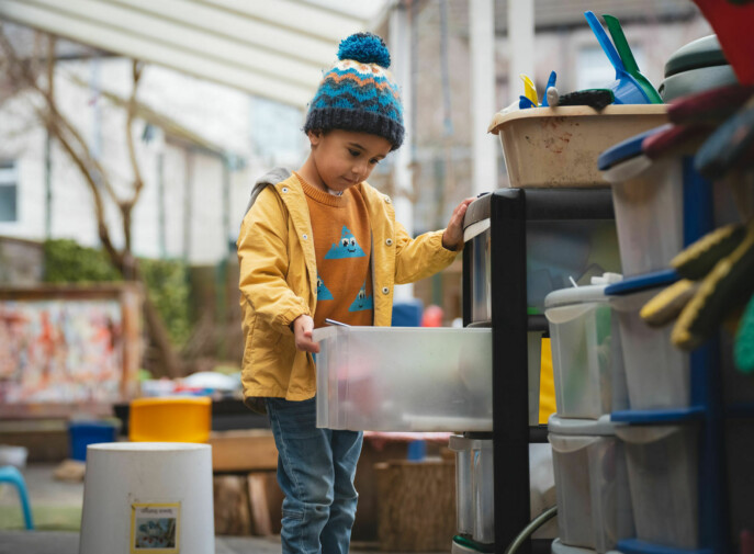 Young boy in yellow coat and hat from childcare tv avdert.