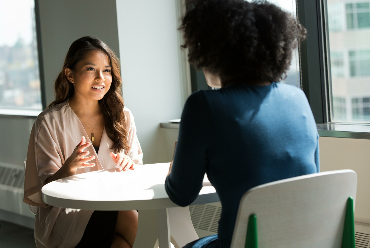 Two people sitting either side of a desk