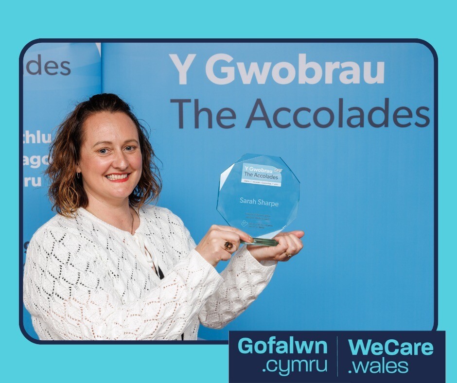 A picture of Sarah Sharpe holding her WeCare Wales trophy.