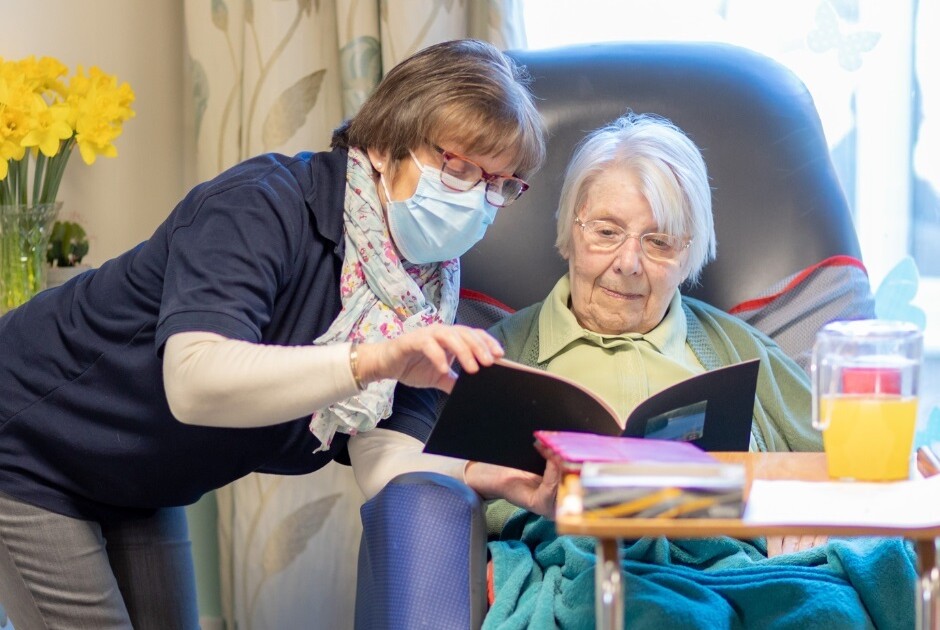 Carer and woman reading a book