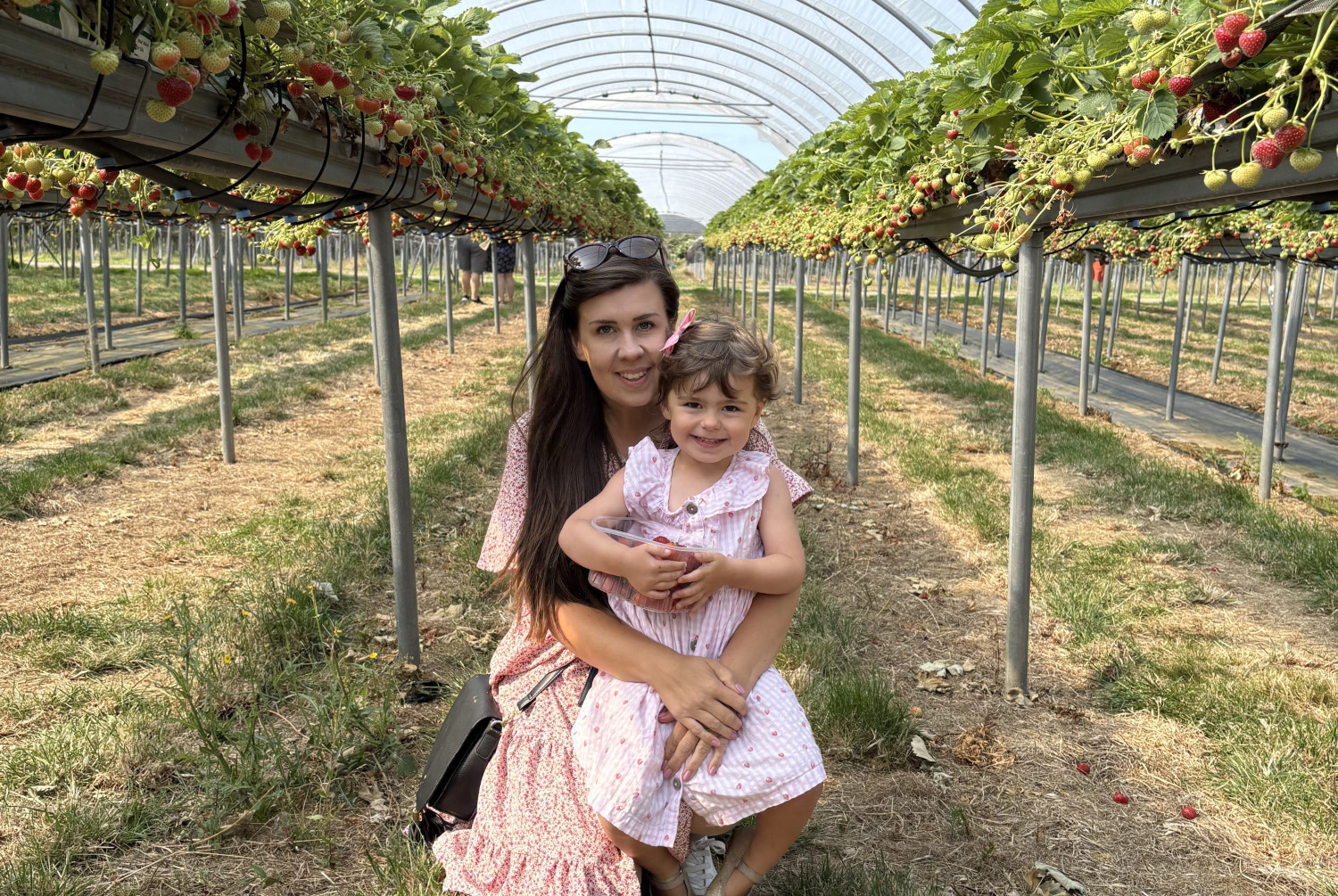 Mam a merch yn gwenu i'r camera